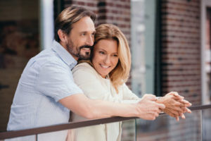 Woman embraced by man smiling after vaginal tightening in New York City